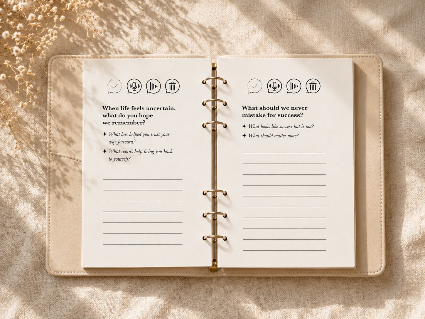 An open CoHear journal showing two guided prompt pages with record, playback, and delete icons, resting on sunlit fabric
